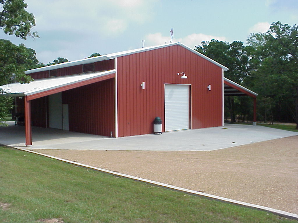 Red 40 by 60 party barn in College Station, Texas with white trim and lean-tos on both sides