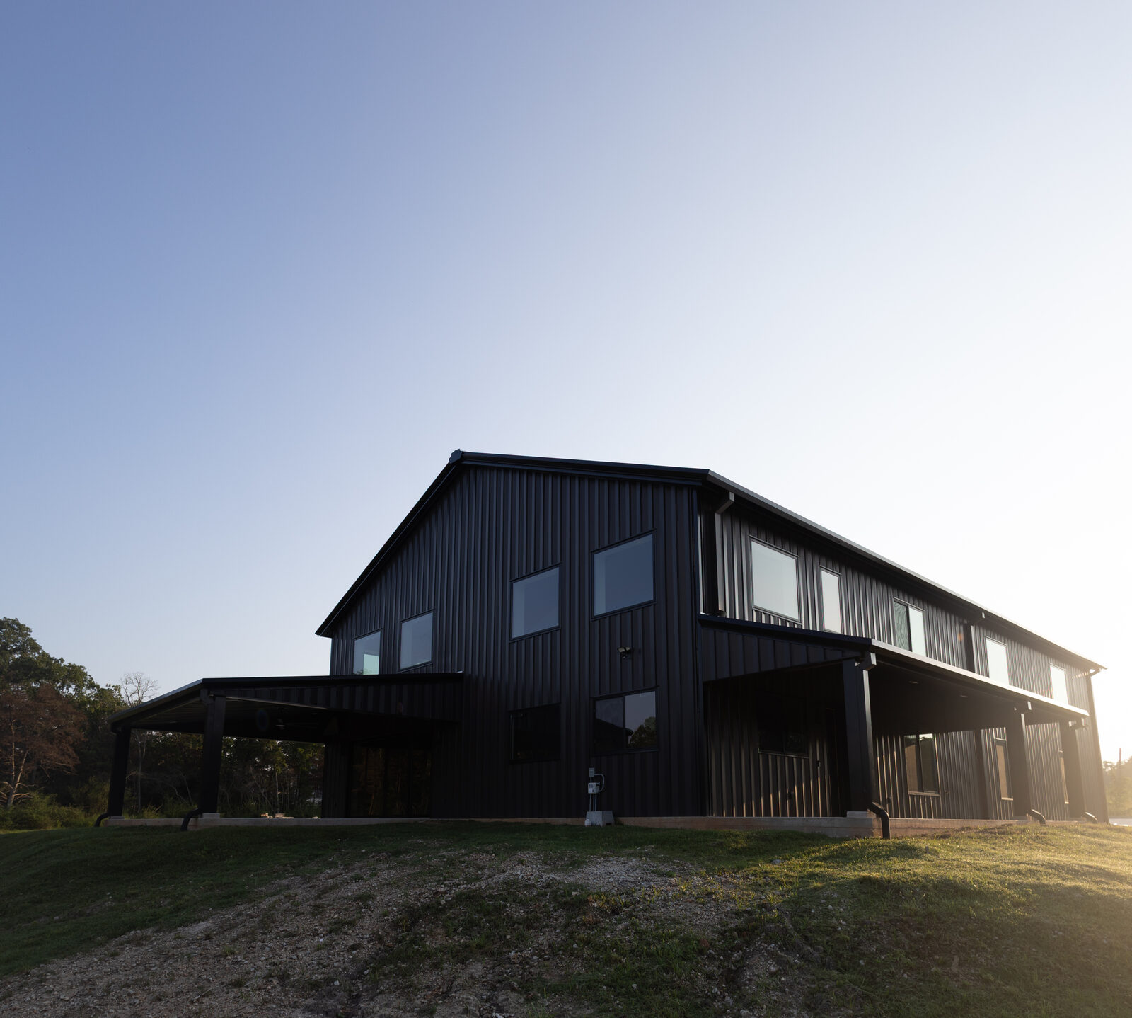 The building at sunset from the gable end, with the covered patio in shadow