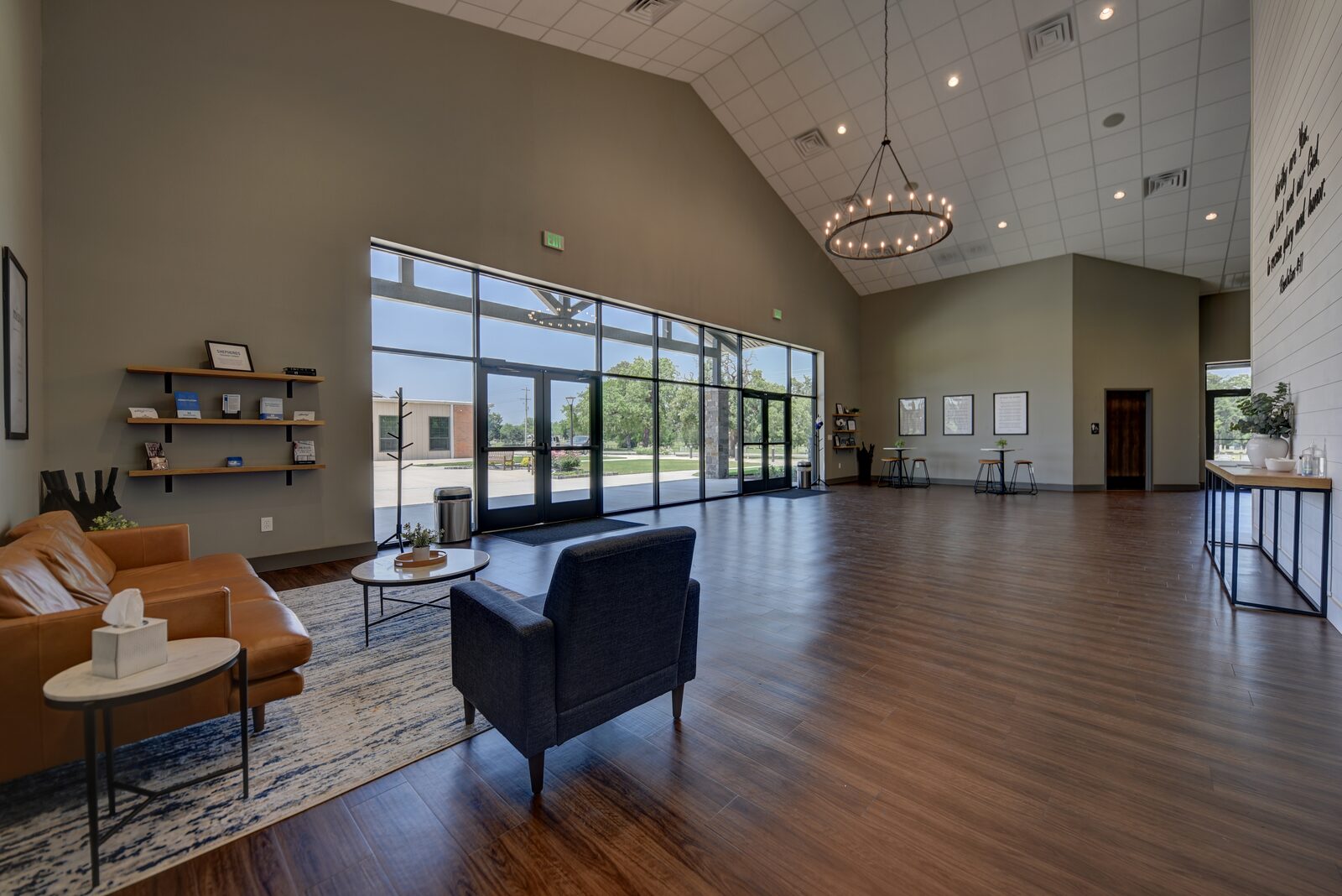 Foyer seating area with leather sofa, chandelier and a full-height glass wall