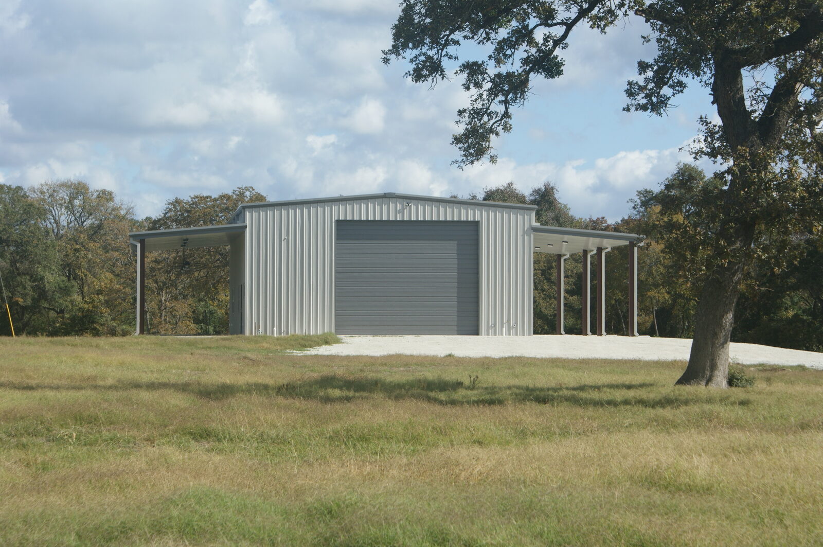 40 by 60 metal building in Franklin, Texas with a 20 foot by 16 foot overhead door and lean-tos on both sides