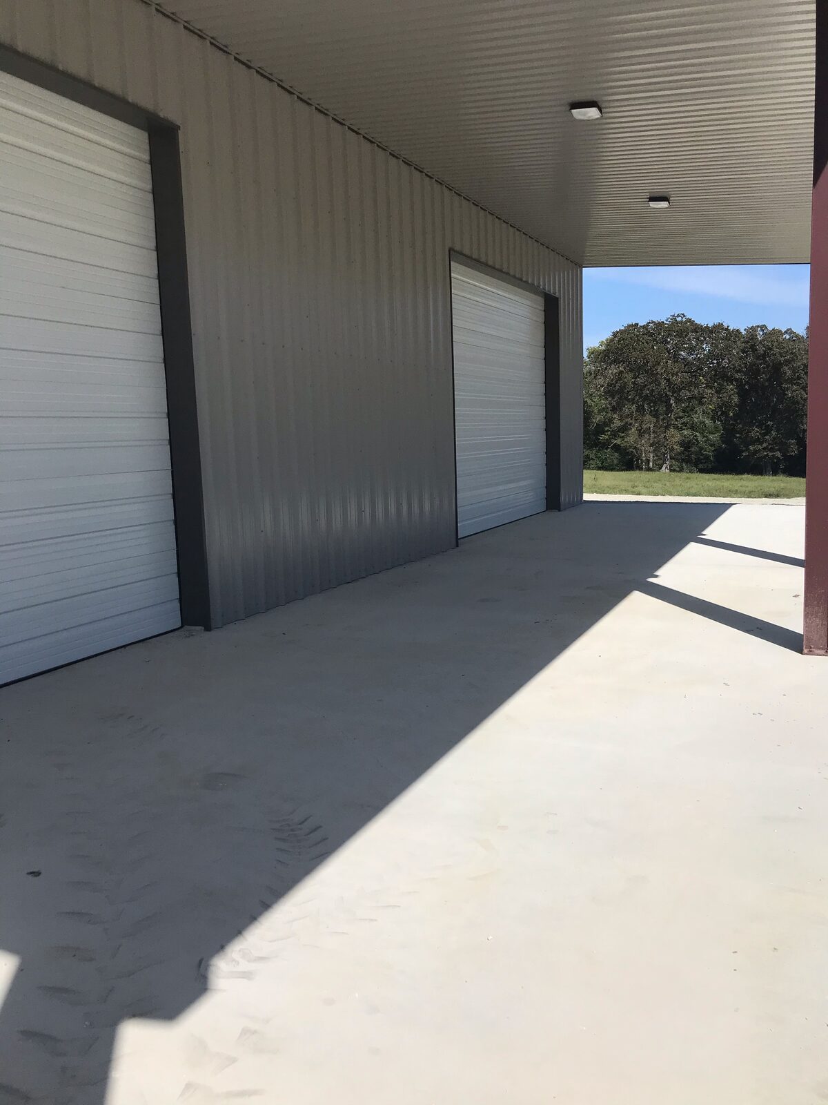 Looking down the sidewall from under the lean-to at the overhead doors and concrete