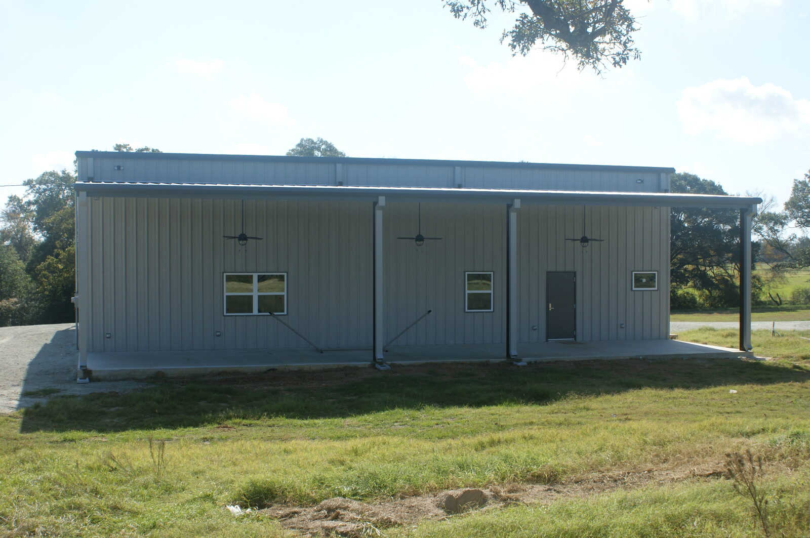 Rear sidewall with windows, a walk door and ceiling fans under the covered lean-to